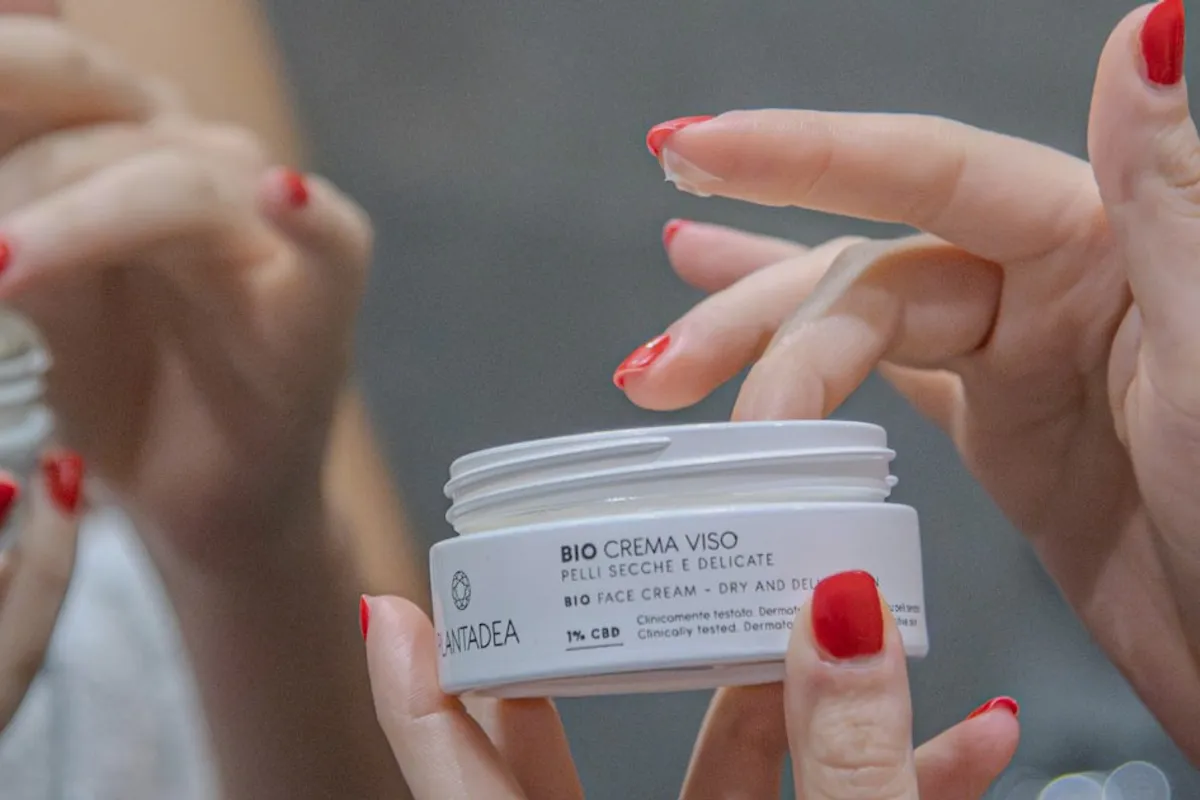 Manos sosteniendo crema facial, fotografía ilustrativa