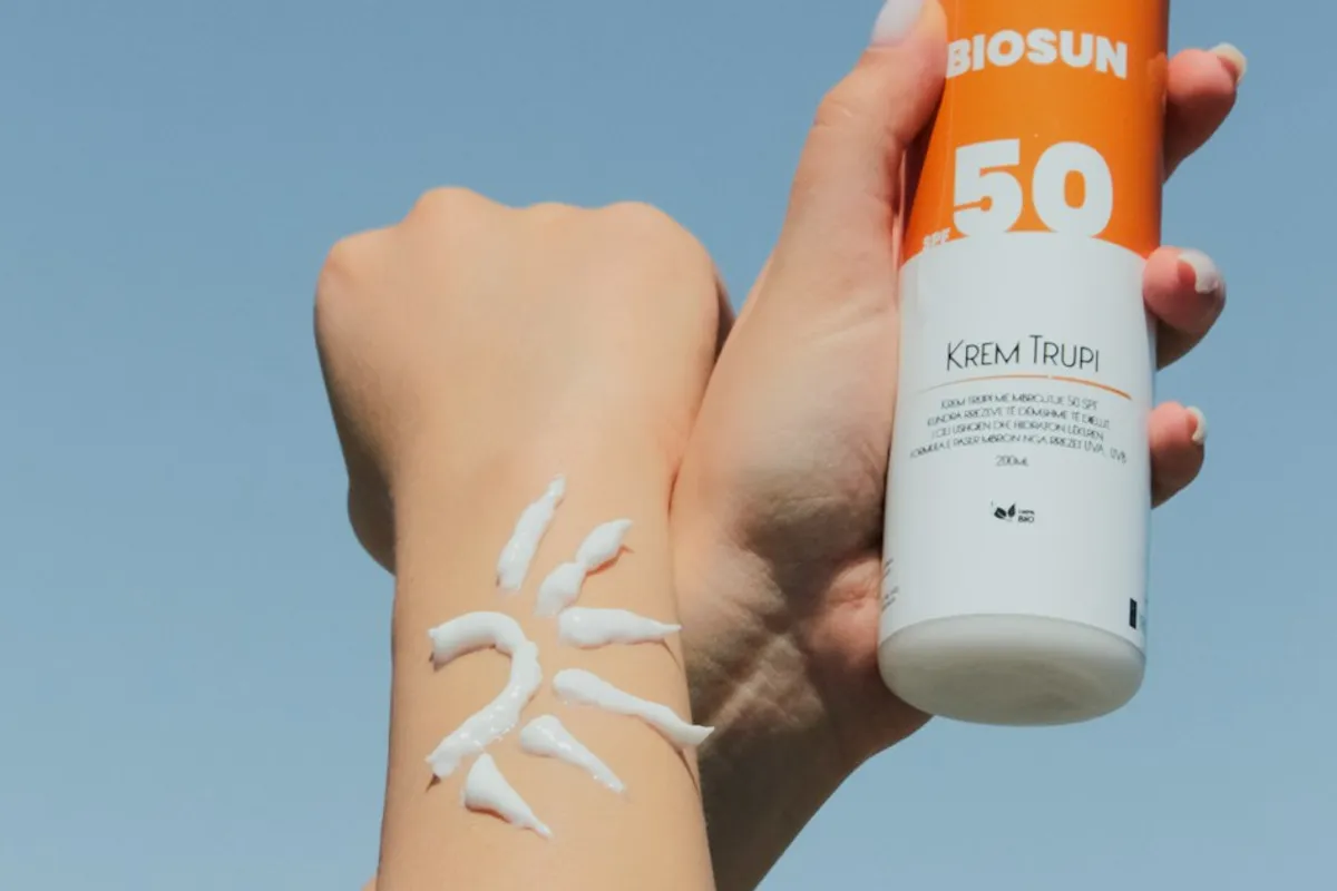 Mano con un envase de protector solar